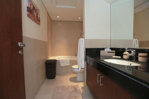 a bathroom with a sink and a toilet and a mirror at Prime Retreats - Downtown Dubai in Dubai