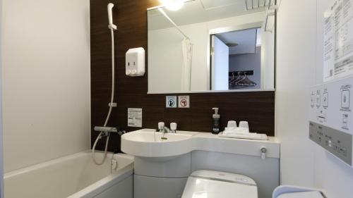 a bathroom with a sink and a toilet and a mirror at Kumamoto Green Hotel in Kumamoto