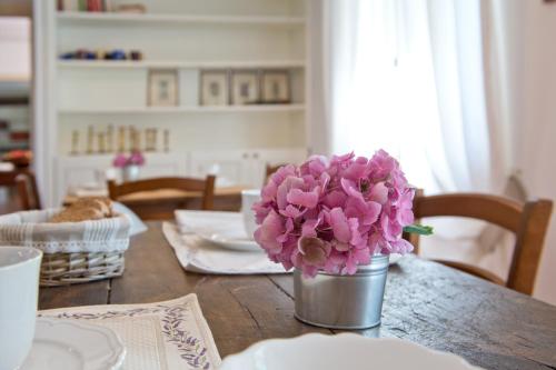 a table with a vase of pink flowers on it at Agriturismo Tra Le Vigne in Buttrio