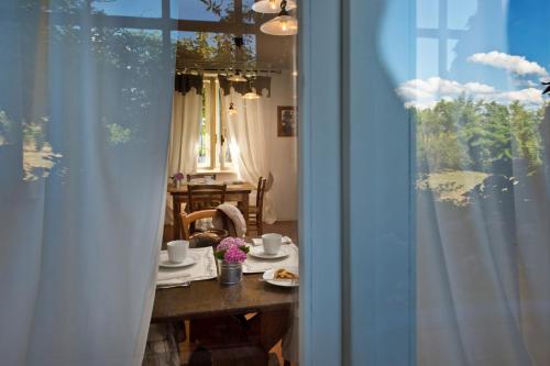 a dining room table with two cups and flowers on it at Agriturismo Tra Le Vigne in Buttrio