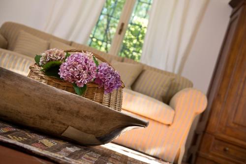 a basket of flowers sitting on a table with a couch at Agriturismo Tra Le Vigne in Buttrio