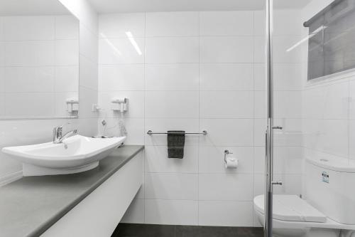 a white bathroom with a sink and a toilet at Comfort Inn Warrnambool International in Warrnambool
