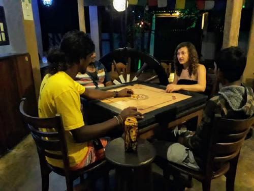 a group of people sitting around a table playing poker at Surfing Life in Ahangama
