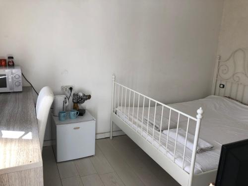 een kleine slaapkamer met een bed en een magnetron bij Emile zola in Rishon LeẔiyyon