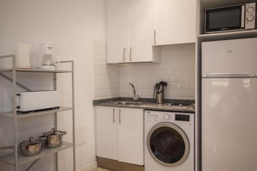 a white kitchen with a washing machine in it at Gran Central Suites in Madrid