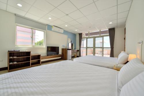 pokój hotelowy z 2 łóżkami i telewizorem w obiekcie Ta Li Wen B&B w mieście Zhushan