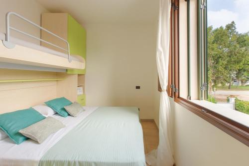a bedroom with a bed and a large window at Appartamento prato inglese sinistro Salento in Specchiolla 