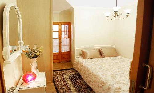 アラコバにあるMelandrinos Apartmentのベッドルーム(ベッド1台、テーブル、鏡付)