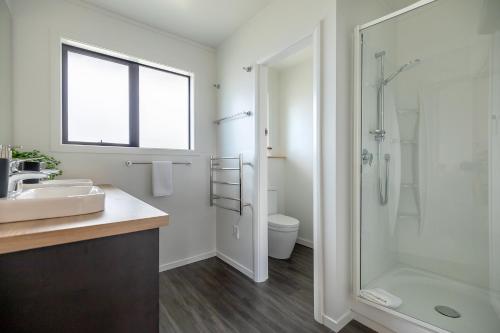 a bathroom with a shower and a sink and a toilet at The Willows Wanaka in Wanaka