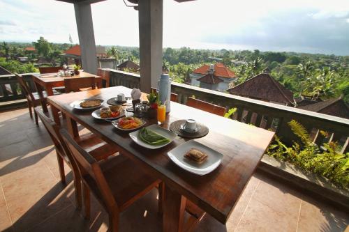 une table avec des assiettes de nourriture au sommet d'un balcon dans l'établissement Hibiscus Cottages, à Ubud