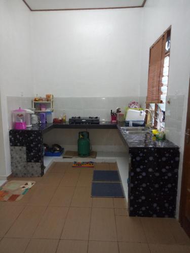 a kitchen with a counter top in a room at Aiman Homestay in Marang