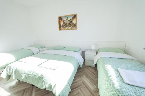 two beds in a room with white walls at Meile House in Rome
