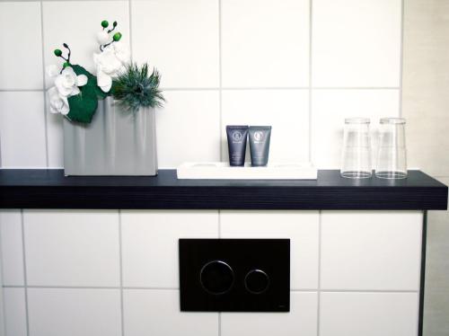 a kitchen counter with a sink and a black stove at City Hotel Bosse in Bad Oeynhausen