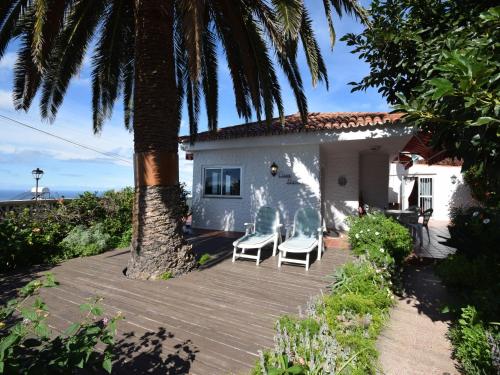 una casa con due sedie e una palma di Cozy Holiday Home in Mesa del Mar with Sea View a Tacoronte