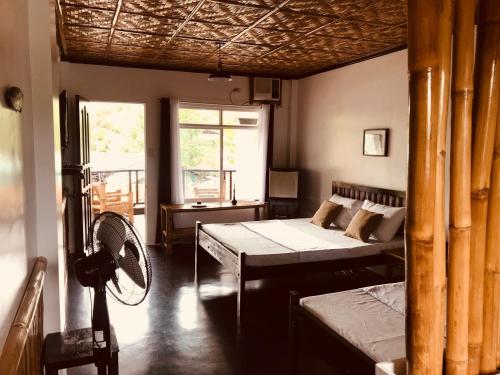 um quarto com 2 camas e uma ventoinha em Everyday Sunday Formerly Carl's Island Inn em Ilha de Bantayan