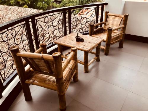 two chairs and a wooden table on a balcony at Everyday Sunday Hotel & Cafe in Bantayan Island