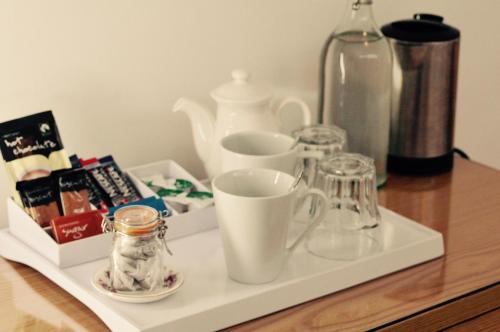 a tray with cups and other items on a table at Pilkingtons Guest House Accrington in Accrington