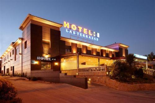 un bâtiment d'hôtel avec un panneau sur celui-ci la nuit dans l'établissement Hotel Las Terrazas, à Albolote