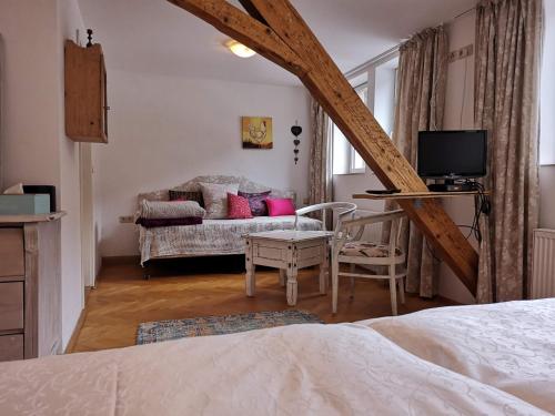 ein Schlafzimmer mit einem Bett und ein Wohnzimmer mit einem Sofa in der Unterkunft Waldgasthaus & Pension Teichhaus in Holzhau