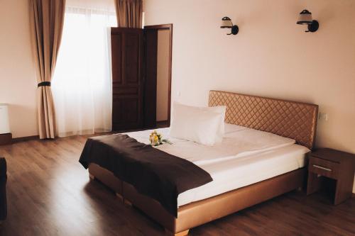 sypialnia z łóżkiem z białą pościelą i oknem w obiekcie Pensiunea Maria w mieście Gilău