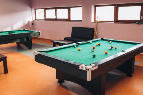 a billiard room with two pool tables and a chair at Pensiunea Maria in Gilău