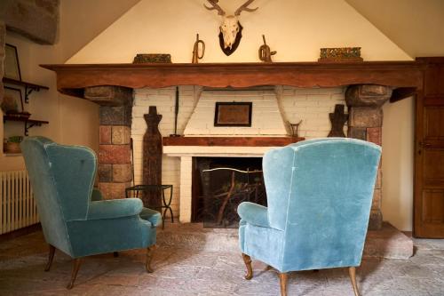 two chairs in a living room with a fireplace at Chalet Vecchio Rifugio - Monte Amiata in Castel del Piano