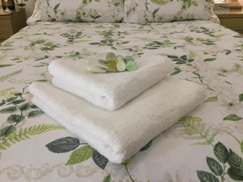 a pile of towels sitting on top of a bed at Pilkingtons Guest House Accrington in Accrington