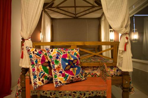 a wooden bed with two pillows on it with curtains at Taj Hotel in Três Lagoas
