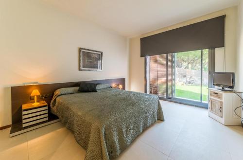 a bedroom with a bed and a television in it at Villa Claudia in L'Escala
