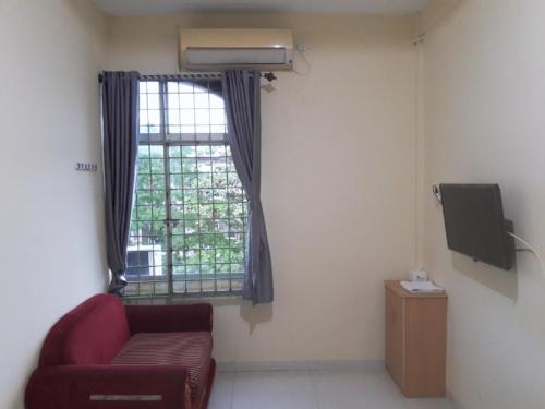 a living room with a red couch and a window at Jakson Homestay in Batam Center