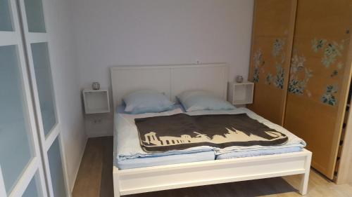 a small bedroom with a white bed with blue pillows at Haus am Prekkesee in Xanten