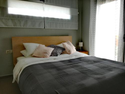 una camera da letto con letto, cuscini e finestra di Spacious and Modern Downtown Apartment a Heraklion