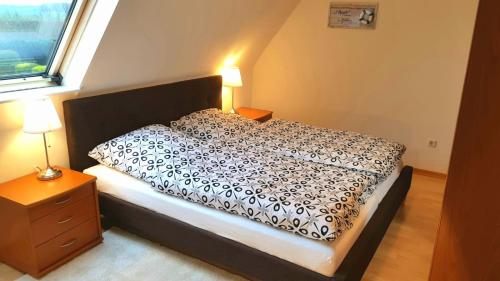 1 cama con edredón blanco y negro en un dormitorio en Ferienwohnung mit wunderschönem Blick auf den Nord-Ostsee-Kanal, en Breiholz