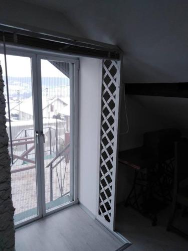 a room with a sliding glass door with a balcony at Apartman Vrdničak in Vrdnik