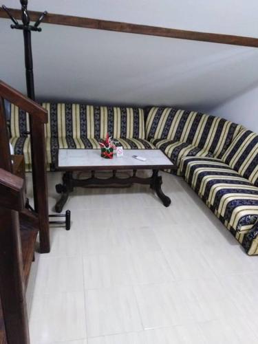 a striped couch with a table in a room at Apartman Vrdničak in Vrdnik