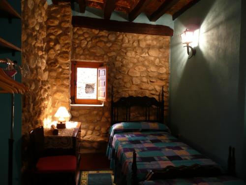 1 dormitorio con 1 cama en una pared de piedra en CAN TRAVÉ, en Crespiá
