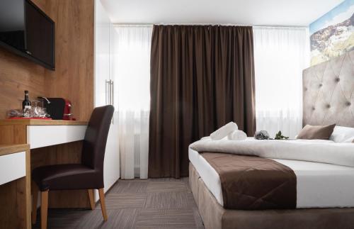 a hotel room with a bed and a chair at Appartements-Dalila in Sankt Michael im Lungau