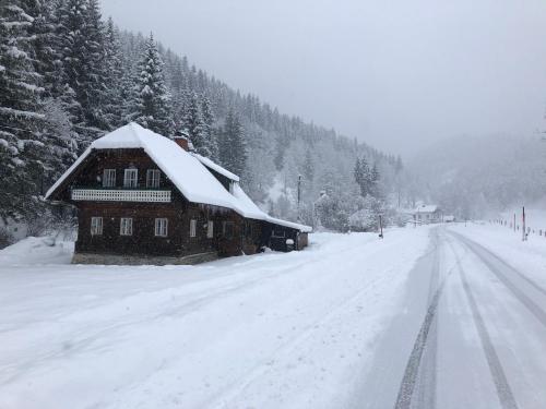 a house covered in snow on a snow covered road at Chalet anno 1794 in Rettenegg