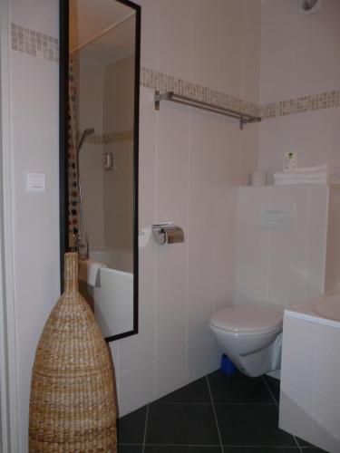 a bathroom with a sink and a toilet and a mirror at Logis Hotel Epi d'Or in Angoulême