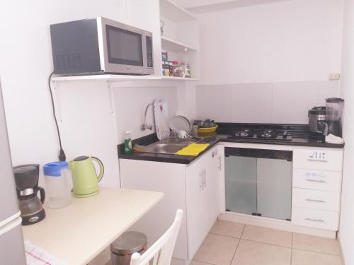 uma pequena cozinha com um lavatório e um micro-ondas em Urban House em Lima