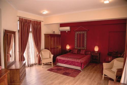 a red bedroom with a bed and two chairs at Villa 49 in Kandy