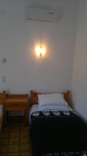 a small bedroom with a bed and a night stand at Hide Away Ipsos in Ýpsos