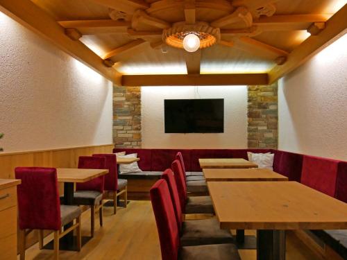 a dining room with wooden tables and red chairs at Hotel Grieserhof in Lermoos
