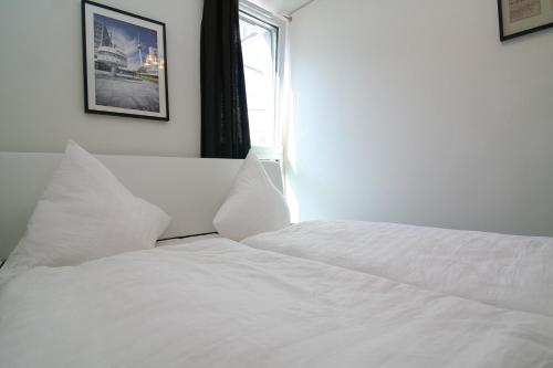 a white bed in a bedroom with a window at Holiday at Alexanderplatz Apartments in Berlin