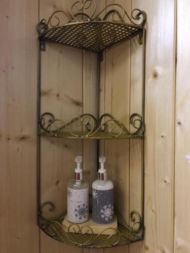 a shelf with two soap bottles on a wooden wall at Chalet anno 1794 in Rettenegg
