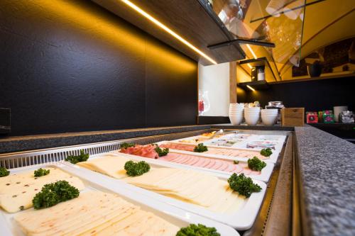 ヴァイセンホルンにあるRiKu HOTEL Weißenhornのさまざまな種類の食べ物が並ぶビュッフェライン