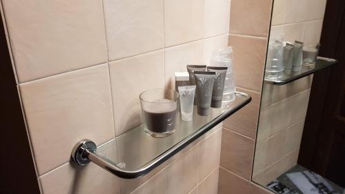 a bathroom with a shelf with cups and a glass at La Suite dei Ricordi in Impruneta