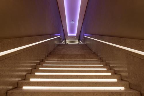 an escalator with a purple light at the top at Áurea Museum by Eurostars Hotel Company in Lisbon
