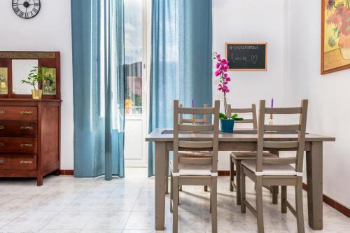una sala da pranzo con tavolo, sedie e orologio di #casuzzabedda a Catania