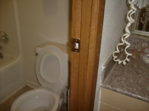 a bathroom with a white toilet and a sink at Express Inn Thomson in Thomson